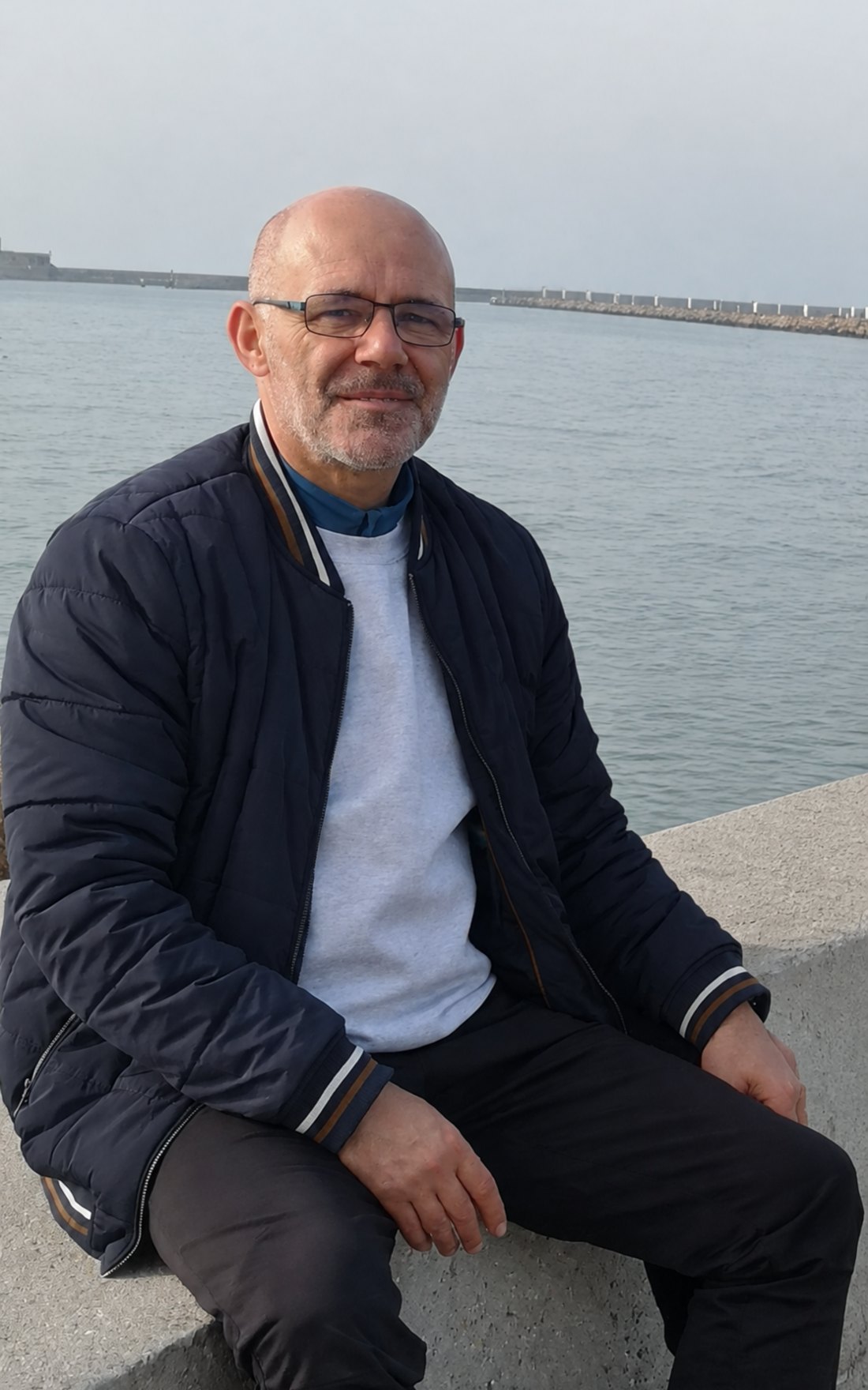 Walter Bridenne, assis face à la mer sur une jetée